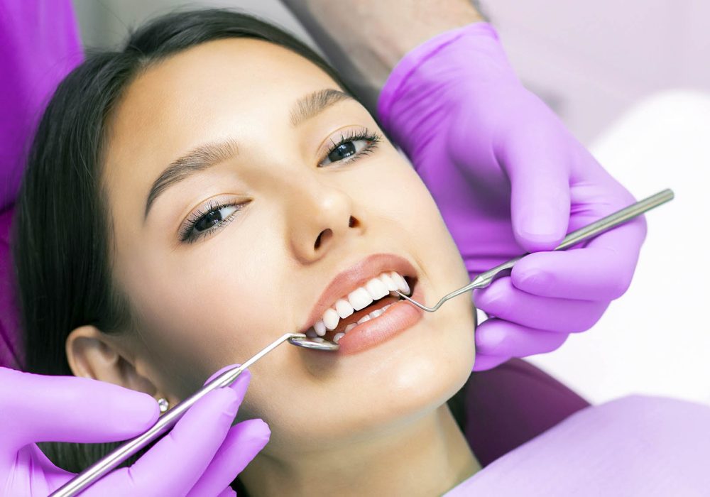 dentist examines the patients teeth at the dentist. dentist examines the patients teeth at the dentist. purple background